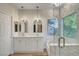 Elegant bathroom featuring dual sinks, modern fixtures, a soaking tub, and a glass-enclosed shower at 3794 Cape Royal St, Las Vegas, NV 89147