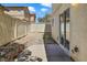 A small backyard area featuring concrete patio, rock features, and perimeter fence at 3961 Bayamon St, Las Vegas, NV 89129