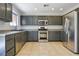 Well-lit kitchen featuring stainless steel appliances, gray cabinets, and tile flooring at 3961 Bayamon St, Las Vegas, NV 89129