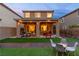 Inviting backyard with covered patio, pavers, seating, artificial turf, and ambient string lights at 397 Purple Sandpiper St, Las Vegas, NV 89138