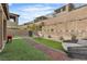 Landscaped backyard with turf, dining area, lounge seating, and mature shrubbery at 397 Purple Sandpiper St, Las Vegas, NV 89138
