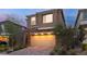 Inviting two-story home with stone accents and a brick driveway, illuminated at twilight at 397 Purple Sandpiper St, Las Vegas, NV 89138