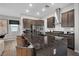 Kitchen island with dark granite countertops and dark brown cabinets, stainless steel hood and appliances at 397 Purple Sandpiper St, Las Vegas, NV 89138