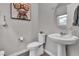 Modern powder room with pedestal sink, toilet, and stylish wall decor at 397 Purple Sandpiper St, Las Vegas, NV 89138