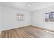 Bedroom featuring light hardwood floors, white walls and two windows with dark trim at 429 N 10Th St, Las Vegas, NV 89101