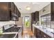 Well-lit kitchen with stainless steel appliances, dark cabinets, and a window overlooking the exterior at 4809 S Torrey Pines Dr # 201, Las Vegas, NV 89103