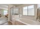 Bathroom featuring a soaking tub, a separate shower, and neutral-toned tile at 5005 Justice Creek Ave, Las Vegas, NV 89131