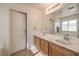 Bathroom includes double sinks, a large mirror, wood cabinets, and a view of the soaking tub at 5005 Justice Creek Ave, Las Vegas, NV 89131