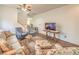 Comfortable living room featuring a cozy sofa, accent chairs, stairs, and a plush area rug at 5005 Justice Creek Ave, Las Vegas, NV 89131