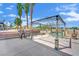 An open patio area with a metal canopy frame and an outdoor seating area, surrounded by mature trees at 5890 W Patrick Ln, Las Vegas, NV 89118