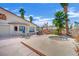 A spacious backyard featuring a spa, a patio with outdoor seating, lush greenery, and tall palm trees at 5890 W Patrick Ln, Las Vegas, NV 89118