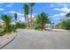 Gravel driveway leads to the two-story home, accented by palm trees and mature landscape at 5890 W Patrick Ln, Las Vegas, NV 89118