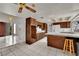 Open-concept kitchen featuring custom wood cabinetry, white countertops, and tile flooring at 5890 W Patrick Ln, Las Vegas, NV 89118