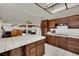 Open concept kitchen with tile countertops, wooden cabinetry, and modern appliances at 5890 W Patrick Ln, Las Vegas, NV 89118