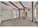 Living room featuring exposed wood beams, bare flooring, and closet space at 5890 W Patrick Ln, Las Vegas, NV 89118
