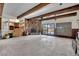 Spacious living room featuring a stone fireplace, wood beam ceiling, and sliding glass doors at 5890 W Patrick Ln, Las Vegas, NV 89118