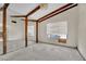 Living room with exposed wood beams, lots of natural light, and bare flooring at 5890 W Patrick Ln, Las Vegas, NV 89118