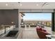 Outdoor living area with a fireplace, comfortable seating, and stunning views of the city skyline at 6 Vista Crescent Ct, Henderson, NV 89012