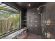 Luxurious walk-in shower featuring multiple shower heads, a bench, dark tiles, and a garden view at 6 Vista Crescent Ct, Henderson, NV 89012