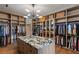Spacious walk-in closet with custom shelving, cabinets, and a central island with a marble countertop at 6 Vista Crescent Ct, Henderson, NV 89012
