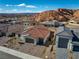 An aerial view of a home with a red tile roof, three-car garage, and desert landscaping at 647 Quarry Pass, Mesquite, NV 89034