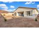 Spacious gravel backyard featuring a covered patio, sliding glass doors, and desert landscaping at 647 Quarry Pass, Mesquite, NV 89034