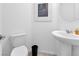 Clean half-bathroom with pedestal sink, toilet, neutral paint, and framed art; bright and simple design at 647 Quarry Pass, Mesquite, NV 89034