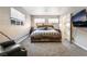 This bedroom features a wood bed frame, brick walls, a mounted TV, and an attached bathroom at 650 Arizona St, Boulder City, NV 89005