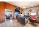 Cozy living room with wood-paneled walls, a stone fireplace, and views into the adjacent sunroom at 650 Arizona St, Boulder City, NV 89005