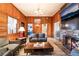 Inviting living room featuring wood paneling, fireplace and views into the modern kitchen at 650 Arizona St, Boulder City, NV 89005