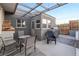 Outdoor patio area with a dining table, chairs, grill, and a stack of firewood at 650 Arizona St, Boulder City, NV 89005