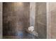 Modern shower with gray stone tile, a built-in corner shelf, and glass partition at 650 Arizona St, Boulder City, NV 89005