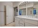 Bathroom featuring double sinks with white cabinetry and a large mirror at 6916 Dorita Ave # 101, Las Vegas, NV 89108