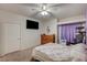 Bright bedroom featuring a ceiling fan, large dresser, television, and a comfortable bed at 6916 Dorita Ave # 101, Las Vegas, NV 89108