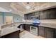 Bright kitchen featuring stainless steel sink, granite countertops, and dark cabinets at 6916 Dorita Ave # 101, Las Vegas, NV 89108