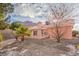 The home's exterior is painted pink with the backyard featuring desert landscaping and mountain views at 7140 Pascal Dr, Las Vegas, NV 89156