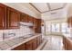 Kitchen featuring light tile countertops, wood cabinets, and stainless steel appliances, with breakfast nook at 7140 Pascal Dr, Las Vegas, NV 89156