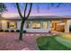 A relaxing backyard view with a small putting green, desert landscaping, and covered patio at 7307 Lansbrook Ave, Las Vegas, NV 89131