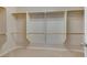 Walk-in closet with carpet features built-in shelving with wooden rods for organized storage at 7307 Lansbrook Ave, Las Vegas, NV 89131
