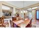 Warm dining room with a view outside and a charming chandelier above the wooden dining table at 7307 Lansbrook Ave, Las Vegas, NV 89131