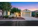 Charming single-story home featuring desert landscaping and a two-car garage at dusk at 7307 Lansbrook Ave, Las Vegas, NV 89131