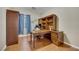 Home office features a built-in wooden desk, shelving, wood floors and a comfortable chair at 7307 Lansbrook Ave, Las Vegas, NV 89131