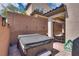 Backyard featuring a luxurious hot tub, surrounded by a brick privacy fence and desert landscaping at 7559 Chimney Point Ct, Las Vegas, NV 89166
