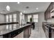 Modern kitchen features a large granite island, stainless steel appliances, and sleek dark cabinetry at 7559 Chimney Point Ct, Las Vegas, NV 89166