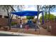 Community playground featuring a blue shade structure, play equipment, and fenced perimeter at 7559 Chimney Point Ct, Las Vegas, NV 89166