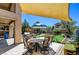 Backyard with a patio, dining set, sun shade, and lush greenery for relaxation and entertaining at 7609 Rory Ct, Las Vegas, NV 89129