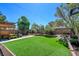 Spacious backyard featuring artificial turf and custom pergola, ideal for outdoor recreation and relaxation at 7609 Rory Ct, Las Vegas, NV 89129
