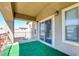 Covered balcony features artificial turf, wrought iron railing, and access to the interior at 7609 Rory Ct, Las Vegas, NV 89129