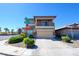 Two-story home featuring a balcony, tan stucco, stone accents, and a well-kept lawn at 7609 Rory Ct, Las Vegas, NV 89129