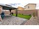Landscaped backyard featuring a brick patio, artificial turf, and a gazebo with curtains at 7721 Sheliak St, North Las Vegas, NV 89084